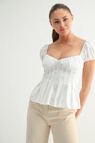 Model wearing white puff sleeve top off the shoulder