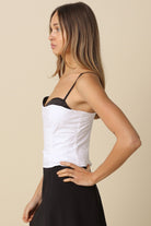 Side profile of the white corset top showing the black peekaboo contrast 