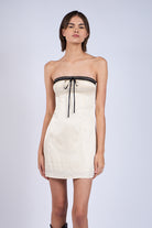 Close-up of white strapless graduation dress featuring a dainty lace neckline.