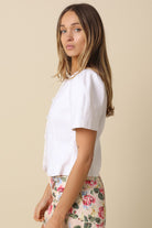 Ivory round neck linen blouse with puff sleeves and button-down front.